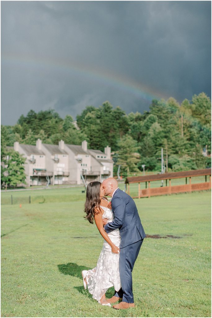 Bride and Groom kissing under a double rainbow in Virginia